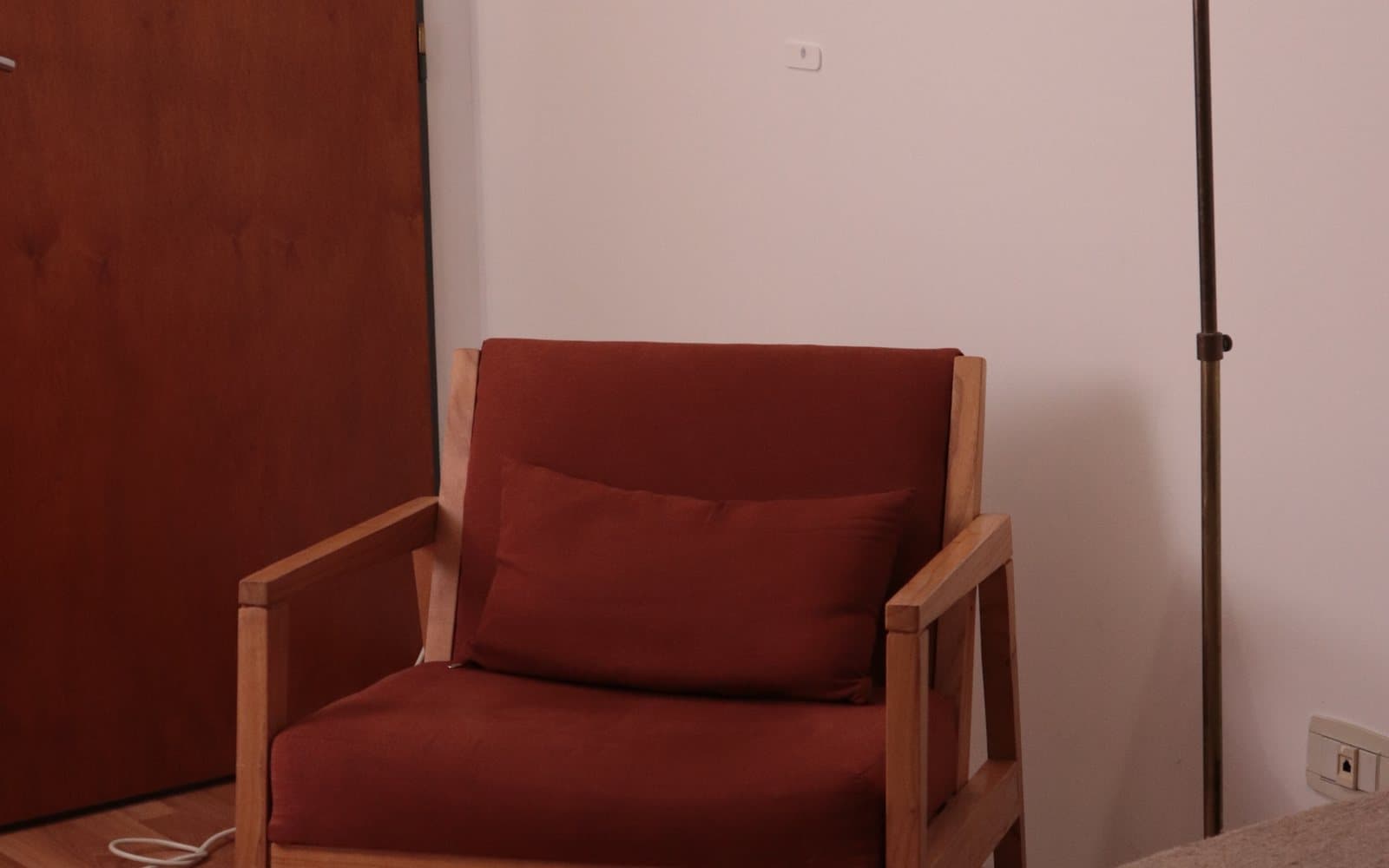 Sillón terracota y lámpara de pie en el consultorio del Dr. Morris Beker, en Villa Crespo.